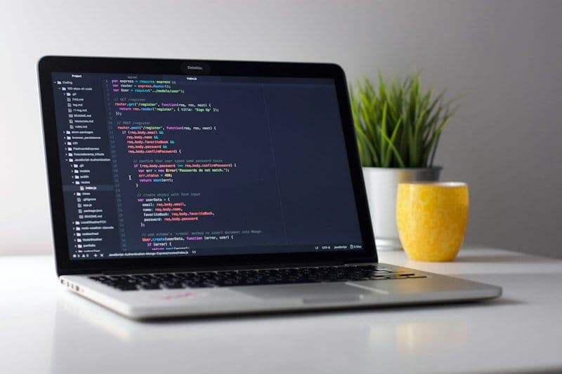 Laptop displaying modern frontend code and interactive components